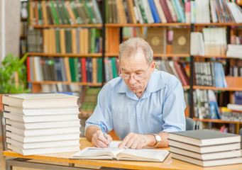Senior man is preparing for the exam in the library