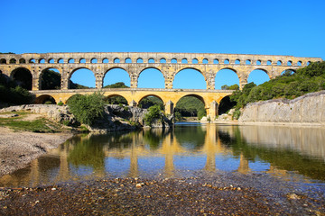 Aqueduct Pont du Gard reflected in Gardon River, southern France