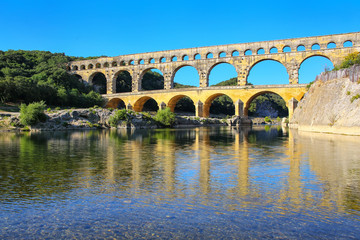 Fototapeta premium Aqueduct Pont du Gard reflected in Gardon River, southern France