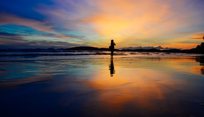 single girl enjoying herself with background of dramatic evening glow during sunset, photo taken on...