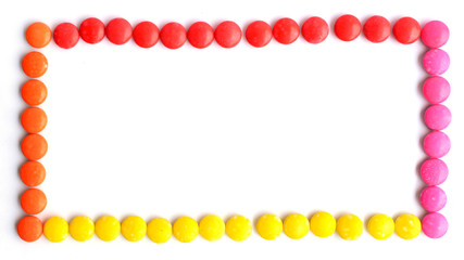 Frame with a pile of colorful chocolate coated candy on white backgrounds above