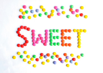 Sweet wording with colorful chocolate coated candy Isolated on white backgrounds above