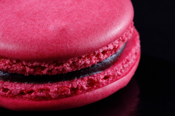 Bright juicy delicious macarons fuchsia on a black background.
