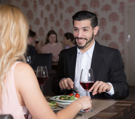 Smiling man with female over dinner with wine