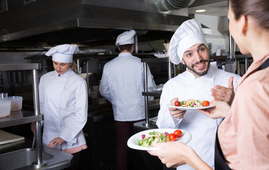 Head chef checking dishes in kitchen