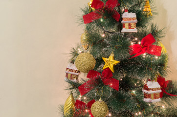 Traditional Christmas tree. Red and golden ornaments and lights on a fake fir tree. Create a festive xmas mood at home.