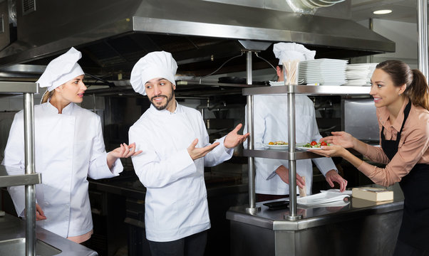 Chef of restaurant with team of cooks preparing food