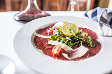 Carpaccio with tomatoes arugula parmesan lemon and red wine