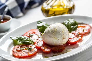 Caprese salad from mozzarella tomatoes basil olive oil an spices