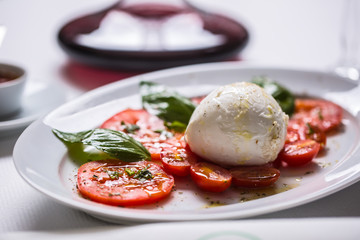 Caprese salad from mozzarella tomatoes basil olive oil an spices