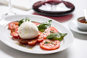 Caprese salad from mozzarella tomatoes basil olive oil an spices