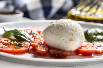 Caprese salad from mozzarella tomatoes basil olive oil an spices