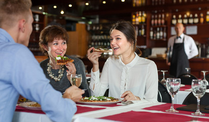 Women with man having dinner in restaurant