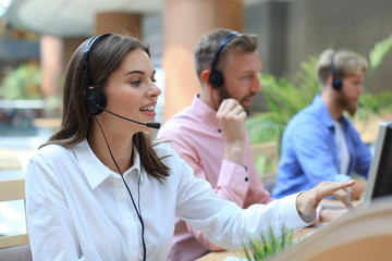 Attractive positive young businesspeople and colleagues in a call center office.