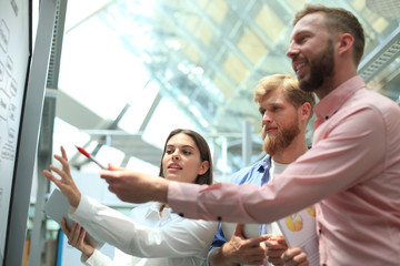 Obraz premium Casual business people working with whiteboard in office.