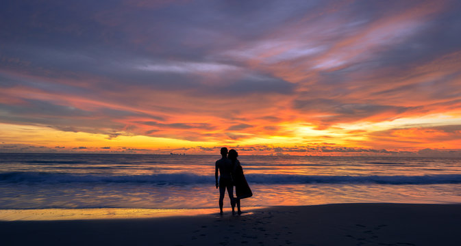 silhouette of young Asian couple during sunset, photo taken on Lanta island beach, Krabi, Thailand.
