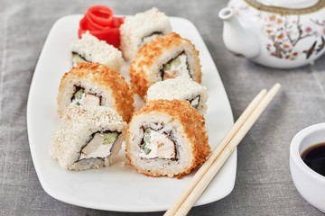 Sushi Set maki on white  plate.Chopsticks, ginger and soy sauce