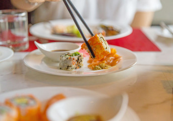 Eating shushi with chopsticks, focus selective