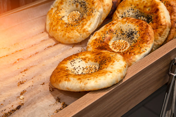 Close-up of tandyr bread cakes freshly baked appetizingly laid out in even rows on the counter of a shopping center in the bakery section. Natural products in the store.