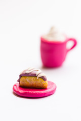 Miniature play dough coffee or latte cup with cream topping, piece of cake on pink plate, white isolated background, artificial food concept, kids craft sculpture, mini art, copy space, coffee shop