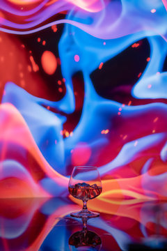 Glass of brandy in front of a large abstract pattern