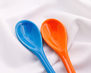 Blue ceramics spoon on white fabric background. Colorful concept.