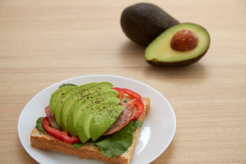 Sandwich with avocado slices and bacon