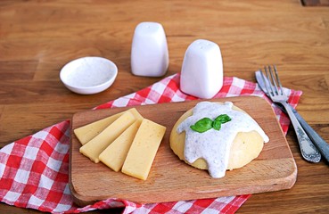 Polenta or hominy, a dish of corn grits or corn flour on a brown background. Served with sour cream and mint sauce.