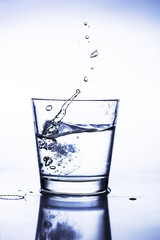 Splash ice cubes in a water glass