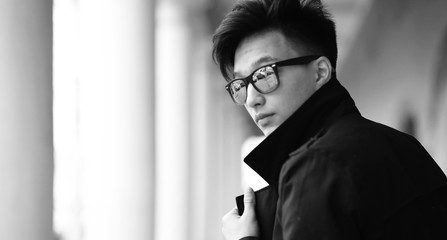 Black White photo of Asian young man outdoors posing