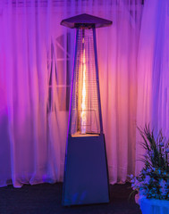 heating lamp heater placed among the tables of an open cafe