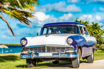 HDR - Blau weißer amerikanischer Oldtimer parkt am Strand auf dem Malecon nahe des Strandes in Havana Cuba - Serie Cuba Reportage