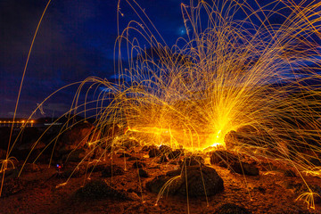 cool burning steel wool fire work photo experiments on the rock at sunrise..