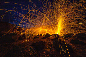 cool burning steel wool fire work photo experiments on the rock at sunrise..