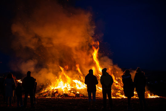 silhouettes of people in frontof big fire