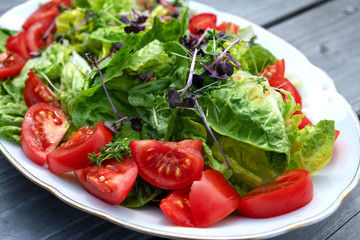 mixed summer salad on wooden ground