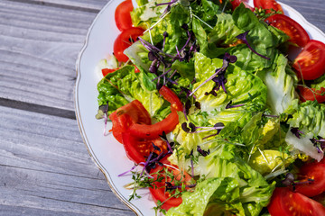 mixed summer salad on wooden ground