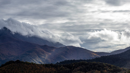 Naklejka na ściany i meble Clouds on a mountain range landscape