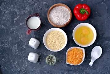 Obraz na płótnie Canvas Ingredients for cooking corn unleavened bread: wheat flour, red peppers, corn flour, oil, salt, pepper, grated cheddar cheese, baking powder, eggs, milk or buttermilk.
