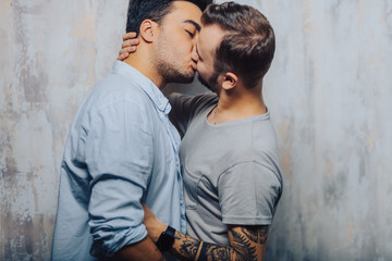 Mixed race couple of Gay Male Sexual Interactions, Asian and Caucasian men cuddling and kissing...