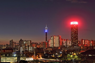 Fototapeta premium JOHANNESBURG, SOUTH AFRICA - June 17, 2017: Sunset view of the Johannesburg city skyline including the Ponte and Hillbrow Towers.