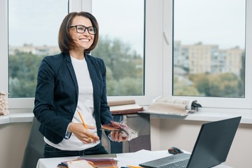 Female decorator interior designer at workplace with fabric samples, laptop. Smiling female in...
