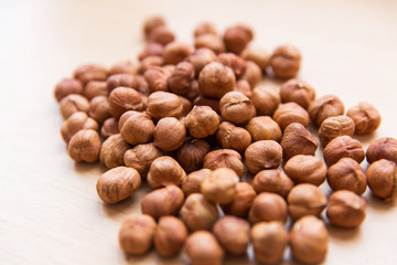 hazelnuts on light wooden background. Texture of hazelnuts. Nuts on the table