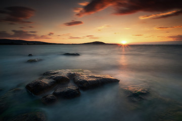 Naklejka na ściany i meble Sea sunrise, near the rocks