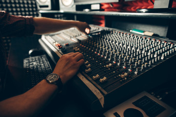 close up cropped side view photo. soundman turning on the device in the music studio.
