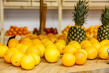 Pineapples and tangerines are on the shelf in the store