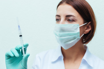 Young nurse in glasses prepares syringe