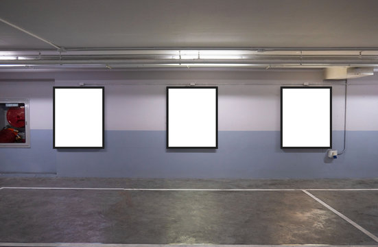 indoor car parking and empty white billboard .Blank space for text and images.