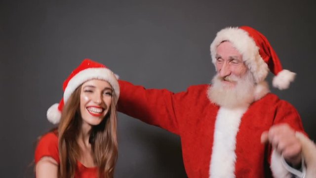 Cheerful santa and female helper dancing after busiest night of the year