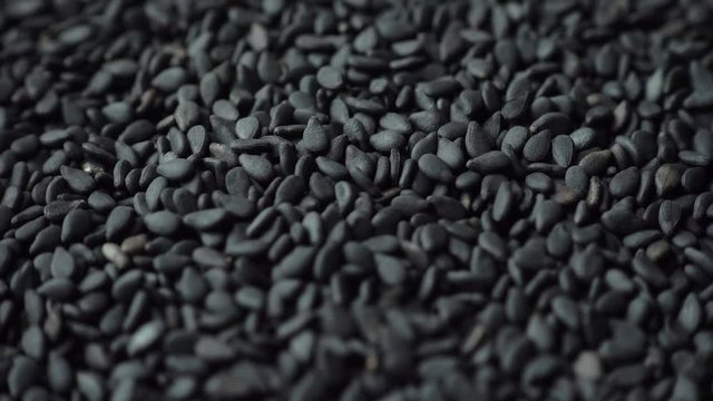 Rotation of black sesame seeds, close-up, 4K